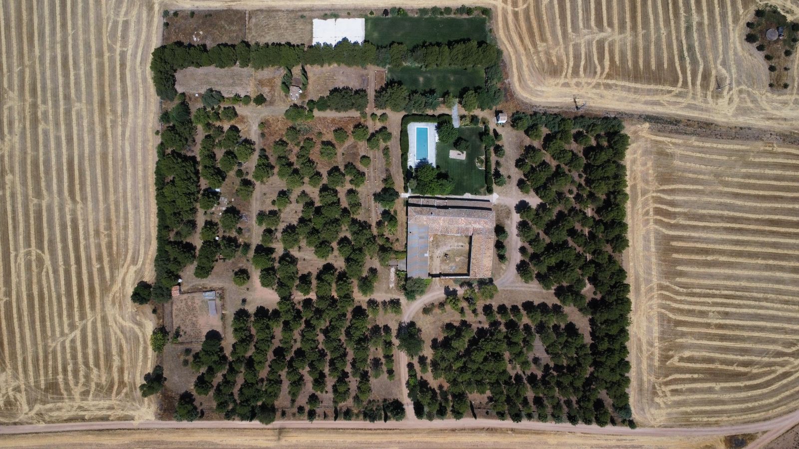 Vista cenital de la finca con la casa, la piscina y los pinares